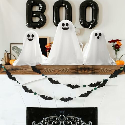 Halloween ghost decorations on a mantle with 'BOO' balloons.