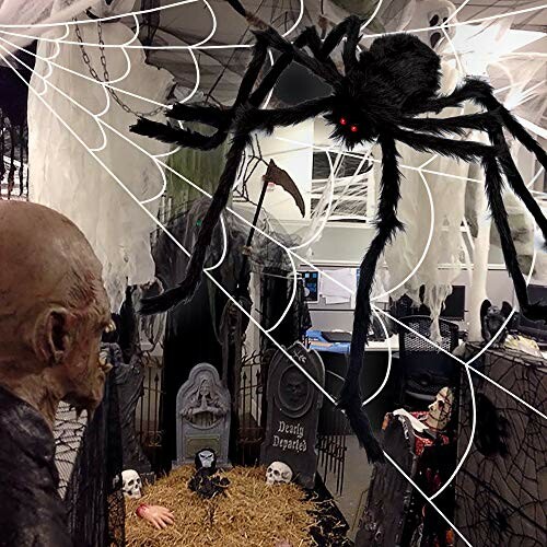 Office decorated with giant spider, cobwebs, and Halloween props.