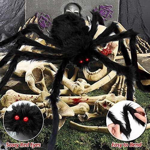 Large black spider with red eyes on a pile of bones, Halloween decoration.